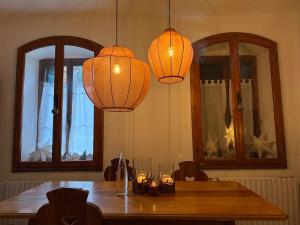 a dining room table with two chandeliers and two mirrors at Cèsa Cusenza in Rocca Pietore +15 photos