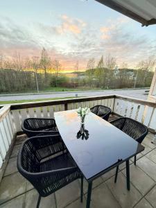 a table with chairs and a vase of flowers on a balcony at Falkenbergsvägen 1C, Ullared in Ullared