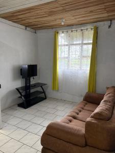 a living room with a couch and a tv at Villa Descanso in Colón