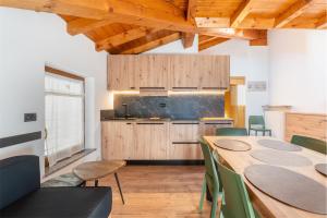 a kitchen with a table and chairs in a room at CROSINA HOLIDAY - Casa Al Ponte in Ledro