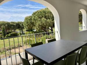 a black table and chairs on a balcony with trees at Elba Essence Suites in Portoferraio
