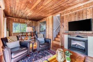 a living room with a fireplace and a flat screen tv at 2BR Beachfront Cottage w/ Grill & Expansive Deck in Point Roberts