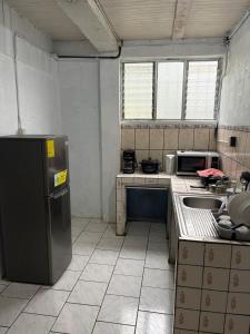 a small kitchen with a sink and a refrigerator at Villa Descanso in Colón