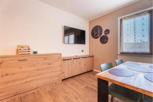 a dining room with a table and a television at CROSINA HOLIDAY - Casa Al Ponte in Ledro