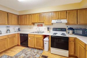 a kitchen with wooden cabinets and a black and white appliance at Sea Oats E106 in Gulf Shores