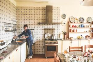 a man standing in a kitchen preparing food at Relax Cascina Lissona in Sessant +6 photos