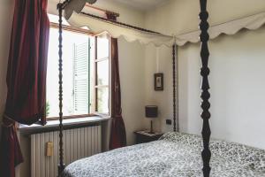 a bedroom with a four poster bed and a window at Relax Cascina Lissona in Sessant