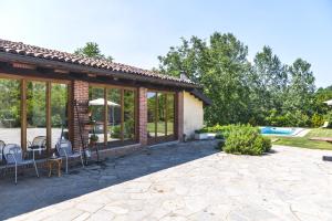 a house with a patio and a swimming pool at Relax Cascina Lissona in Sessant