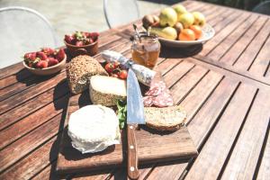 a wooden table with a sandwich and fruit on it at Relax Cascina Lissona in Sessant