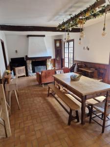 a living room with a table and a fireplace at La Chênaie in Crespin