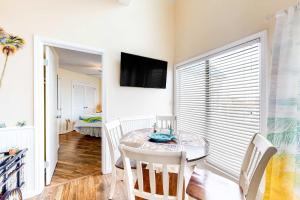 a dining room with a table and chairs and a television at Plantation West #1354 in Gulf Shores