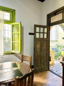 a dining room with a wooden table and a door at La Escondida de Tigre in Tigre