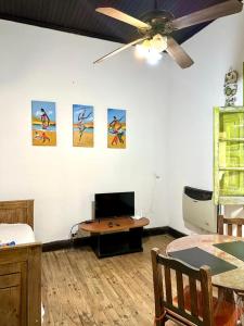 a living room with a ceiling fan and a table at La Escondida de Tigre in Tigre