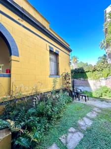 a yellow building with a window and a bench at La Escondida de Tigre in Tigre