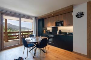 a kitchen and dining room with a table and chairs at L'Altima Megève in Megève