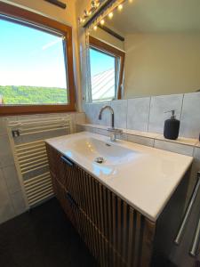 a bathroom with a sink and a large window at Fantastic apartment with unique panoramic views in Kuchl in Größing +22 photos