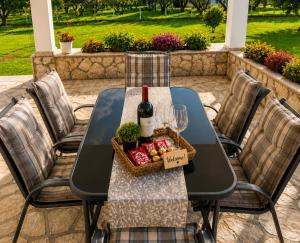 a table with a bottle of wine and a basket of fruit at Private Villa Sea View BBQ in Epanomi