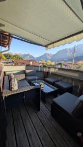 a balcony with couches and tables and a view of mountains at Fantastic apartment with unique panoramic views in Kuchl in Größing