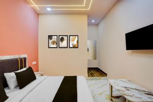 a bedroom with a bed and a flat screen tv at Hotel O DELIGHT INN in Chandrapur