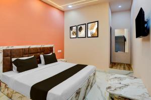 a bedroom with a large bed and a television at Hotel O DELIGHT INN in Chandrapur