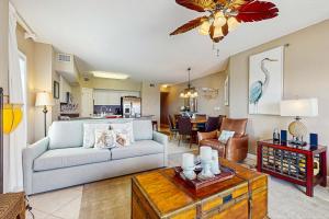 a living room with a couch and a table at Beachfront condo with shared pool outdoor shower and beach access in Gulf Shores
