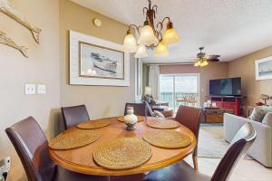 a dining room with a wooden table and chairs at Beachfront condo with shared pool outdoor shower and beach access in Gulf Shores