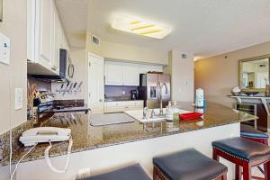 a kitchen with a counter top with stools in it at Beachfront condo with shared pool outdoor shower and beach access in Gulf Shores +27 photos