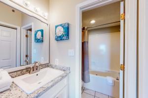 a bathroom with a sink and a mirror and a tub at Tidewater 601 in Orange Beach +20 photos