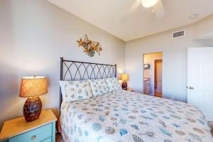 a bedroom with a bed and a lamp on a night stand at Tidewater 601 in Orange Beach