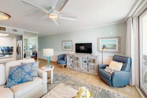 a living room with a couch and a tv at Gulf-front condo with breathtaking views pool in Orange Beach