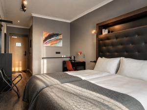 a bedroom with a large bed with a large headboard at ASKA Holt in Reykjavík
