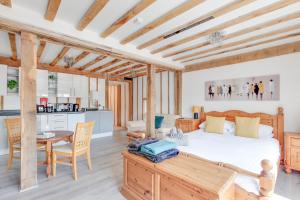 a bedroom with a bed and a table and a kitchen at Maldon Executive Apartments in Maldon