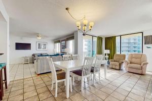 a dining room and living room with a table and chairs at The Whaler 7B in Gulf Shores
