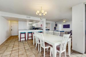 a dining room and kitchen with a white table and chairs at The Whaler 7B in Gulf Shores