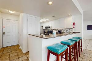 a kitchen with a counter and stools in a room at The Whaler 7B in Gulf Shores +18 photos