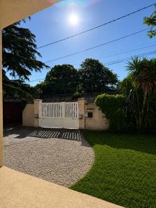 a driveway with a white fence and a yard at Villa Patja in Béziers