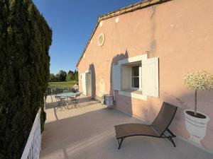 a chair sitting on a patio next to a building at Mas des Fleurs in Châteaurenard +5 photos
