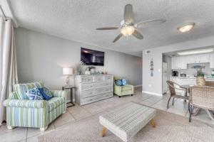 a living room with a ceiling fan and a dining room at Gulf front condo with great views shared pools & beach access in Orange Beach