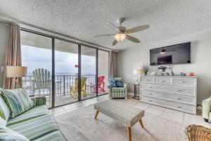 a living room with a couch and a television at Gulf front condo with great views shared pools & beach access in Orange Beach