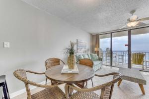 a living room with a table and chairs and a couch at Gulf front condo with great views shared pools & beach access in Orange Beach +24 photos
