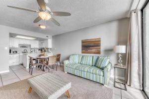 a living room with a couch and a table at Gulf front condo with great views shared pools & beach access in Orange Beach