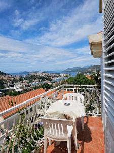 a balcony with two white chairs and a table at Guest House Banana in Dubrovnik