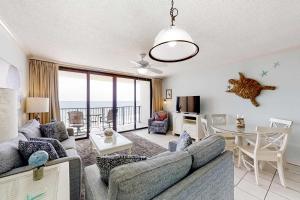 a living room with a couch and a table at Beachfront Condo with Gorgeous Gulf View Balcony & Shared Pools in Orange Beach