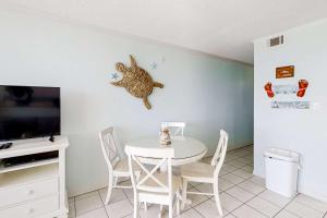 a dining room with a white table and chairs at Beachfront Condo with Gorgeous Gulf View Balcony & Shared Pools in Orange Beach