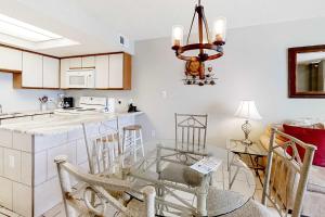 a kitchen with a bar and a table with chairs at Beachfront Condo with Gulf View Balcony WiFi AC & Shared Pools in Orange Beach