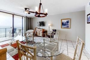 a living room with a glass table and chairs at Beachfront Condo with Gulf View Balcony WiFi AC & Shared Pools in Orange Beach
