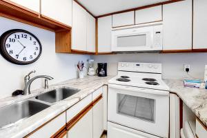 a kitchen with a sink and a clock on the wall at Beachfront Condo with Gulf View Balcony WiFi AC & Shared Pools in Orange Beach +15 photos