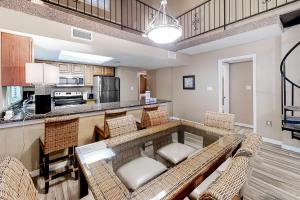 a large living room with a bar with chairs at Gulf-front corner condo with wraparound balcony pools beach access in Orange Beach