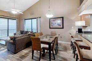 a living room with a couch and a table with chairs at Gulf-front corner condo with wraparound balcony pools beach access in Orange Beach