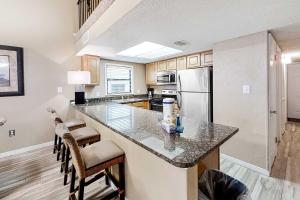 a kitchen with a large island with bar stools at Gulf-front corner condo with wraparound balcony pools beach access in Orange Beach